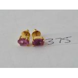 A pair of pink stone earrings set in gold