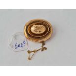 An oval gold target brooch with locket back, 10.5g