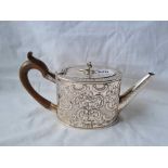 A George III oval teapot embossed with flowers and scrolls 9 1/2 inches over handle London 1779 by