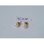 A pair of pearl earrings set in gold