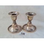 A pair of candle sticks with circular bases, 3” high, B'ham 1910
