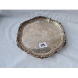 A Victorian circular salver with scroll engraved centre with claw and ball feet 9 inches dia