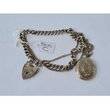 A silver curb link bracelet with heart shaped padlock together with metal locket on chain