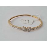 An attractive hinged bangle set with CZ ribbon bow in 9ct - 8.4 gms inc