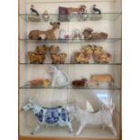 A glazed cabinet with model cows, churns etc