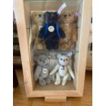 A group of five miniature Steiff Bears in glazed case