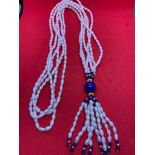 A three strand fresh water pearl and lapis bead necklace
