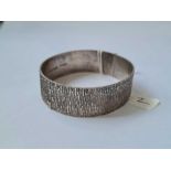 A wide bark effect hinged silver bangle - 33 gms