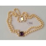 A pearl necklace with amethyst and pearl pendant and gold clasp