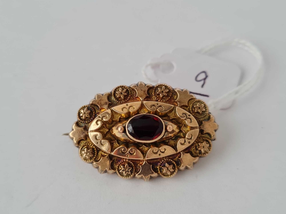 A attractive antique mourning brooch/locket with central garnet set in gold