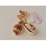 A pair of unusual gold topped small cowrie shell earrings