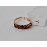 A seven stone garnet band ring size O - 2 gms