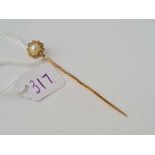 A pretty pearl and diamond cluster stick pin set in high carat gold