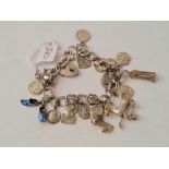 A silver fancy link charm bracelet with 16 charms and medals - 37.5 gms