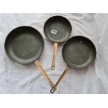 Group of three copper frying pans with brass handles