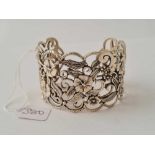 A ornate silver floral bangle - 48.2 gms