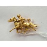A UNUSUAL DESIGNER BROOCH OF A PONY WITH RUBY EYE AND RIDER APPEARING TO HURL A BALL IN 18CT