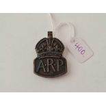 A silver A.R.P badge