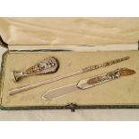 A decorative white metal and gilt desk set of seal, paper clip and nip holder, cased