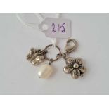 A three charm pendant on clasp including silver butterfly flower and fresh water pearl
