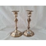 A pair of Queen Anne style candlesticks with octagonal baluster shaped bodies and detachable nozzles