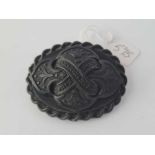 A carved black large brooch