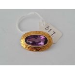 A Victorian pretty oval brooch with central amethyst set in high carat gold