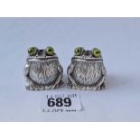 A pair of cast silver salt and pepper cruets in the form of seated frogs with enamel eyes -