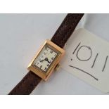 A ladies small rectangular wrist watch in rose gold