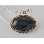 A antique oval and polished agate brooch with paste boarder one stone missing