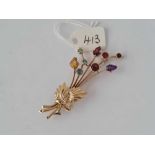 A attractive flower brooch with numerous coloured real gem stones 9ct - 7.8 gms