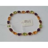 A MULTI GEM SET BRACELET (PERIDOT GARNET CITRINE AMETHYST ) 14CT GOLD - 9.1 GMS