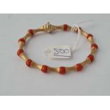 A FANCY 18CT GOLD AND CORAL BRACELET - 13.6 GMS