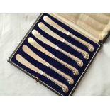A boxed set of six pistol handled tea knives with silver blades - Sheffield 1926