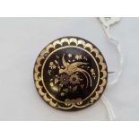 A antique Victorian circular pique brooch inlaid with gold measures 1.6 inches diameter