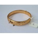 A HINGED BANGLE ENGRAVED WITH SCROLLS 9CT - 14.8 GMS