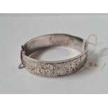 A vintage silver bangle with engraved scroll decoration hallmarked B'ham 1960