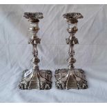 A pair of early Victorian candlesticks, the shape bases with shell decorated cornices and baluster