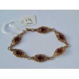 A attractive panel link bracelet each panel set with a garnet 9ct - 7.8 gms