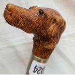 A carved wood walking stick with a push button that opens mouth