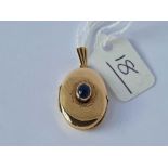 A oval hinged locket inset with a cabochon sapphire 9ct - 2.9 gms