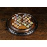 A Victorian Turned Wooden Solitaire Board with air-twist glass marbles, 10¼" (26 cm) in diameter.