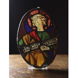 A Gothic Style Stained Glass Oval Panel depicting a saint with inscribed banner,