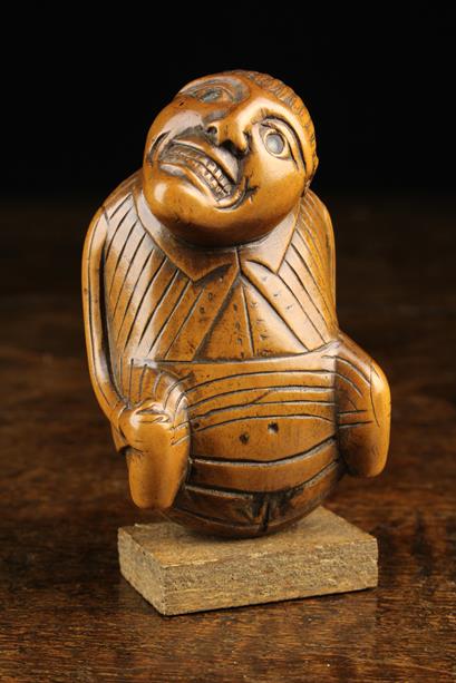 An Early 19th Century Carved Boxwood Snuff Box in the form of a defecating man.