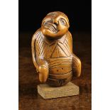 An Early 19th Century Carved Boxwood Snuff Box in the form of a defecating man.