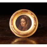 A Small 18th/Early 19th Century Wooden Roundel painted with the head of The Virgin wearing a head