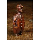A Coquilla Nut Snuff Box carved in the form of a Comical Man wearing a long coat with inset button;