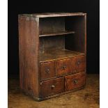 An 18th Century Boarded Oak Spice Cupboard having a shelves upper section above a band of three