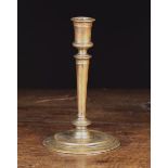 A 16th Century French Pillar Candlestick with tapering stem leading down to a flat moulded circular