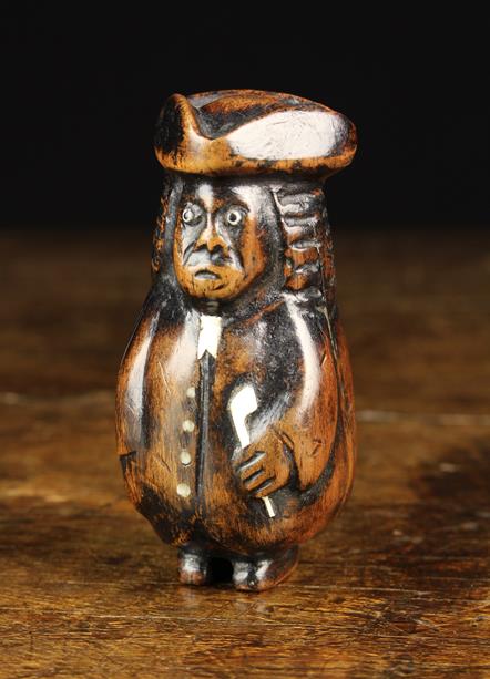An 18th/19th Century Stained Walnut Snuff Box carved as a bewigged curmudgeonly gentleman with